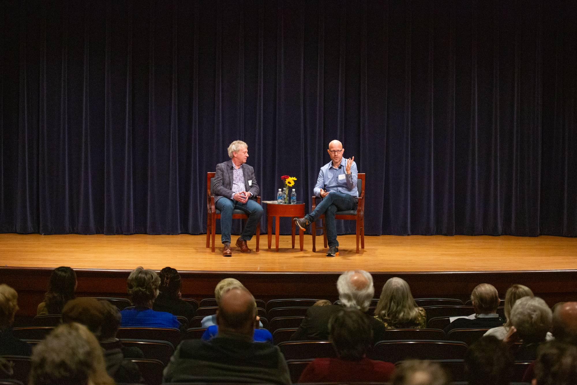two people sitting on stage